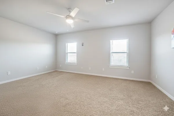 an empty room with a window and a ceiling fan