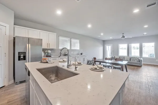 a kitchen with a sink a stove and chairs