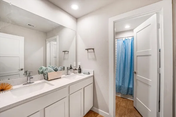 a bathroom with double sink and a mirror