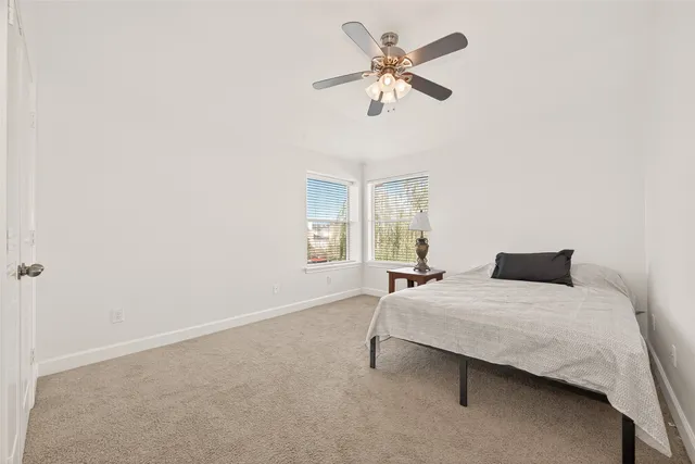 an empty room with a ceiling fan and a window