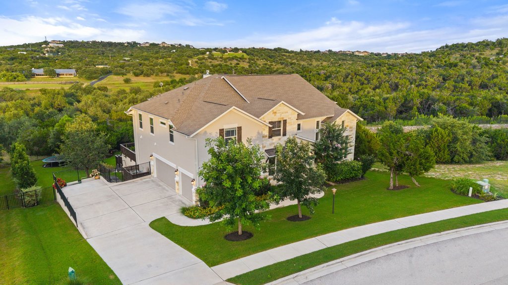 215 Lodestone Lane Austin, TX 78738 - Photo 12 of 40 An inviting suburban residence with a pristine lawn and private driveway, nestled against a wooded hillside.