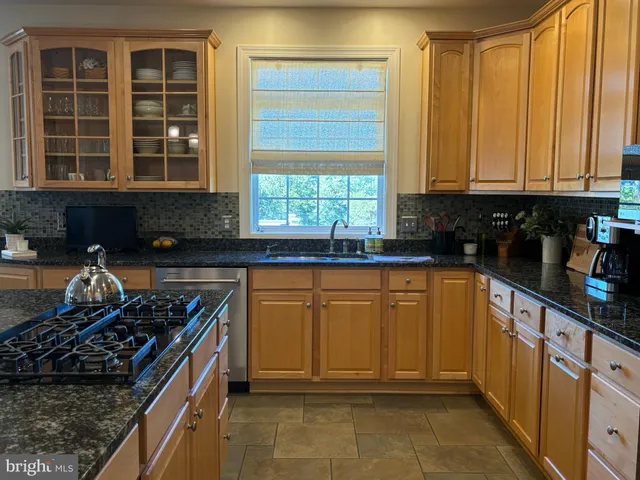 a kitchen with stainless steel appliances granite countertop a stove a sink and a granite counter tops