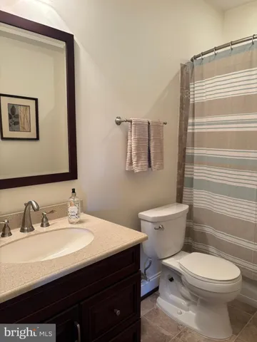 a bathroom with a sink a toilet and shower curtain