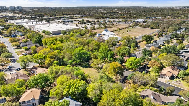an aerial view of residential houses with outdoor space and trees