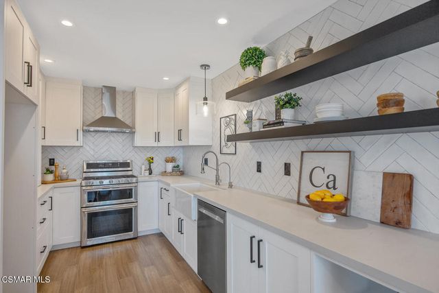 a kitchen with white cabinets stainless steel appliances and sink