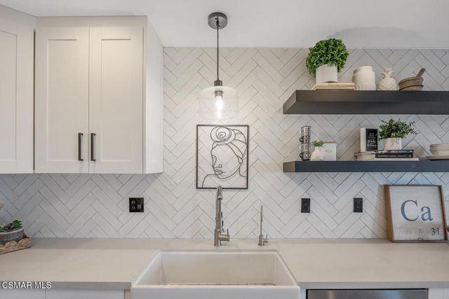 a kitchen with a sink a stove and cabinets