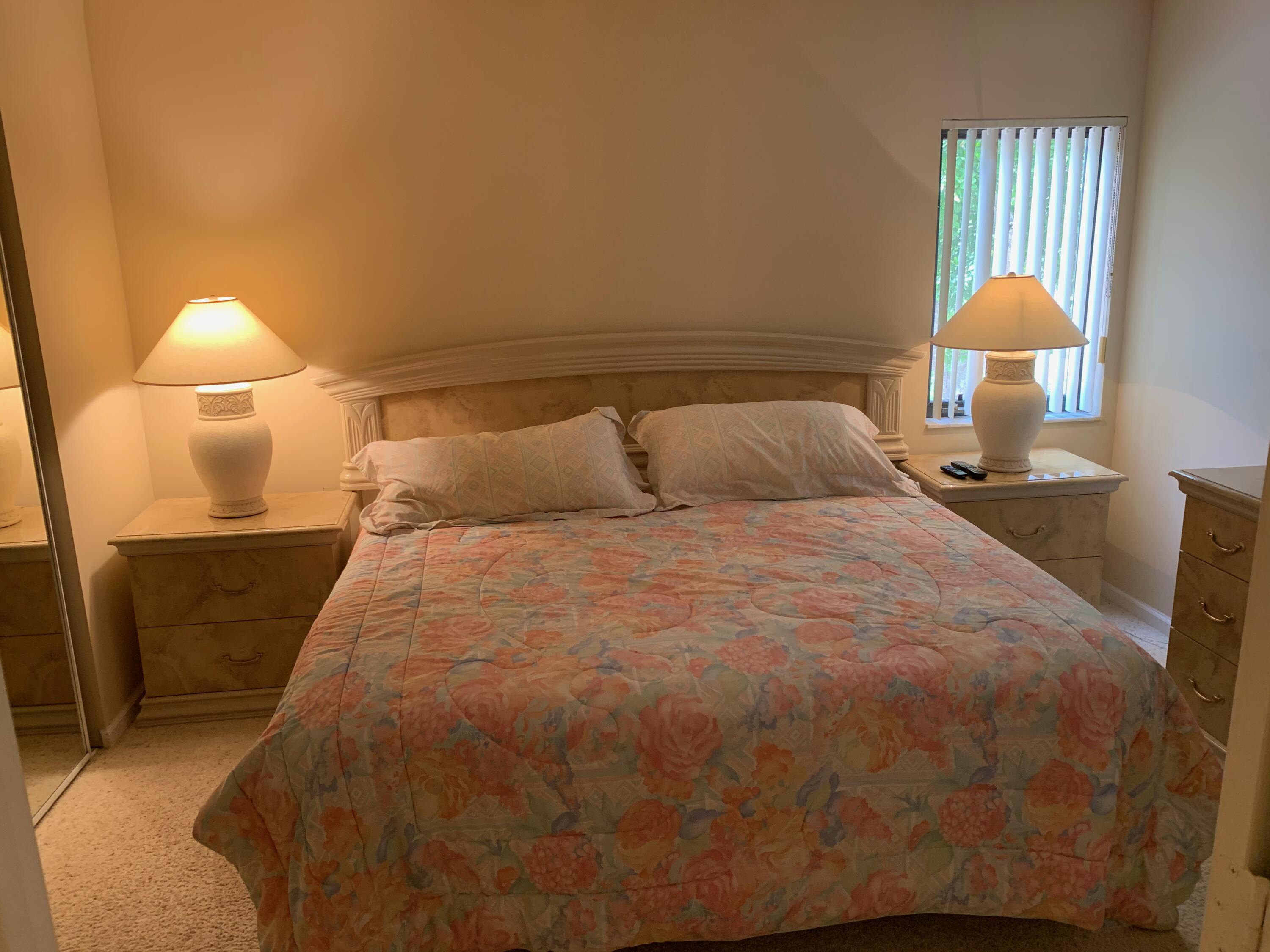49 Uno Lago Drive Juno Beach, FL 33408 - Photo 11 of 18 a bedroom with a bed and a lamp