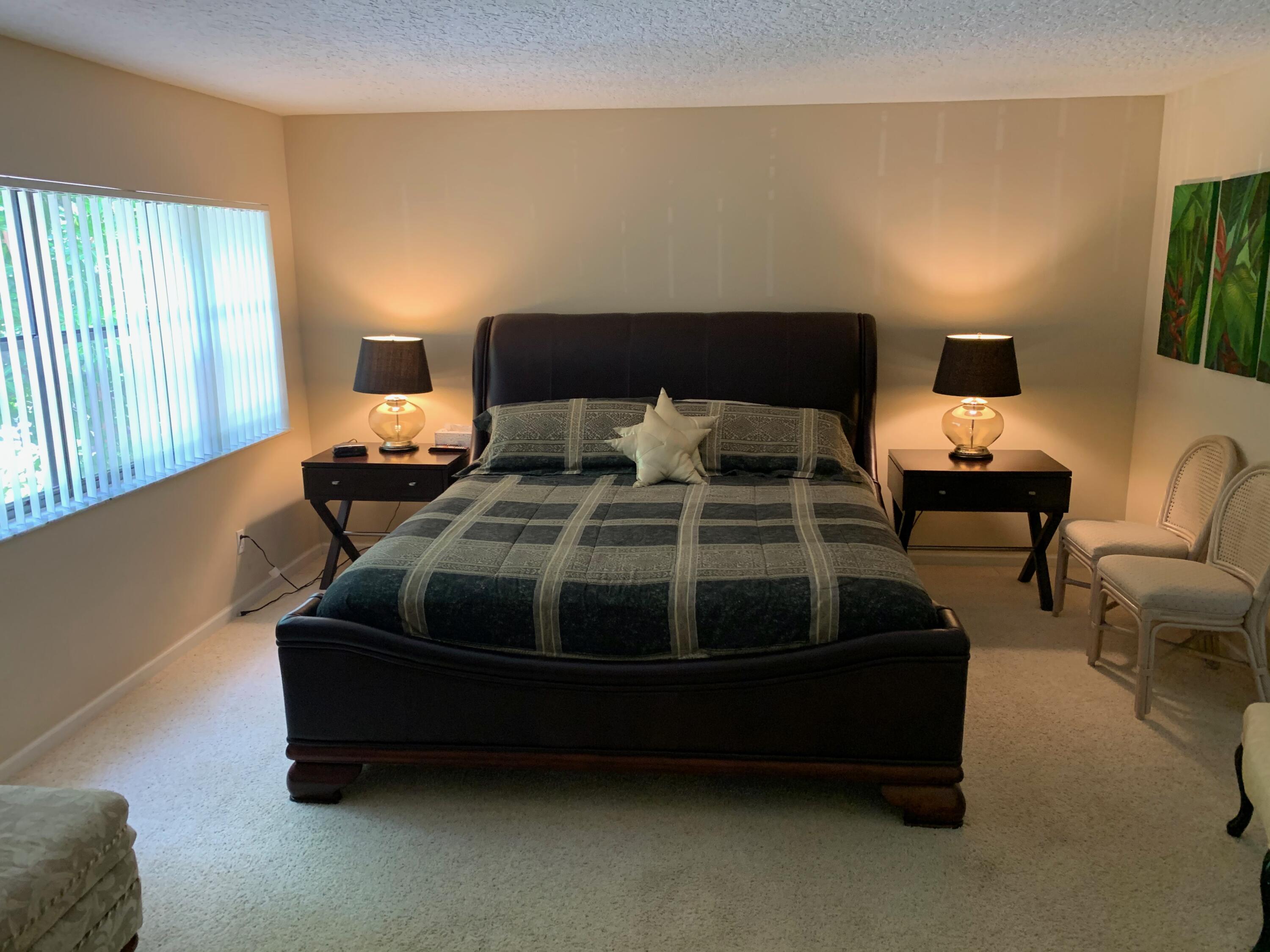 49 Uno Lago Drive Juno Beach, FL 33408 - Photo 8 of 18 a bedroom with bed and window