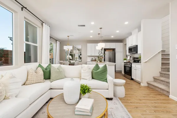 a living room with furniture kitchen and a table