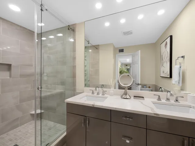 a bathroom with a double vanity sink mirror and shower