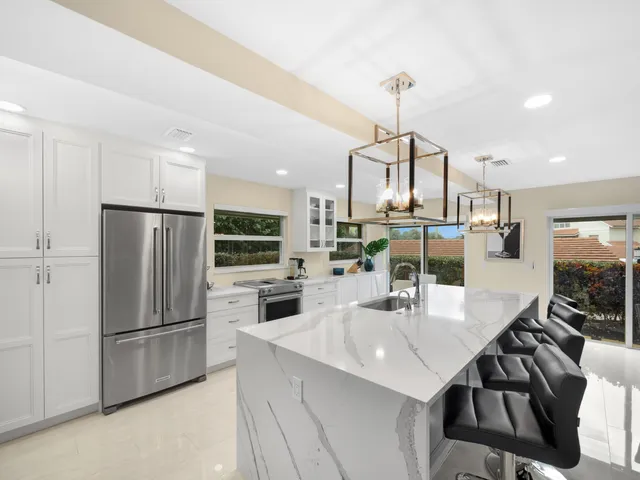a kitchen with kitchen island a counter top space a sink appliances and cabinets