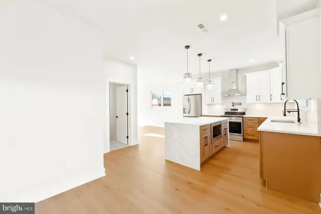 a large white kitchen with cabinets