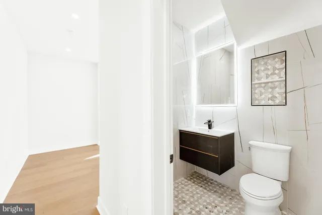 a bathroom with a bathtub sink vanity mirror and toilet