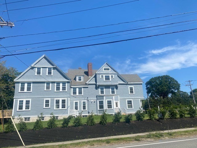 25 Ripley Road, Unit 1 Cohasset, MA 02025 - Photo 14 of 14 a front view of a house with a yard and garage