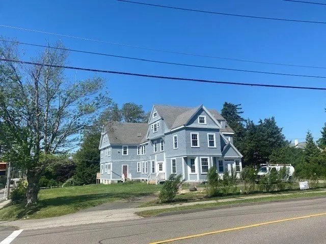 a view of a big house next to a road and yard