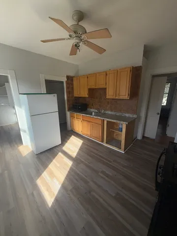 a view of wooden floor and a kitchen
