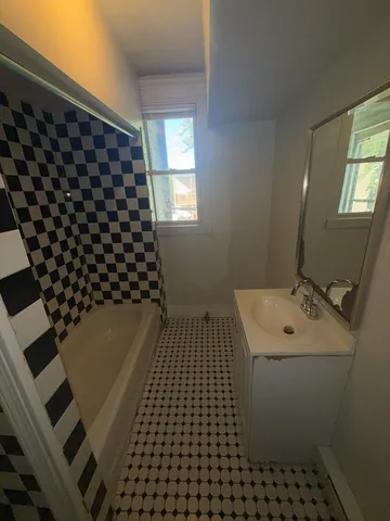 a bathroom with a sink a toilet a window and vanity