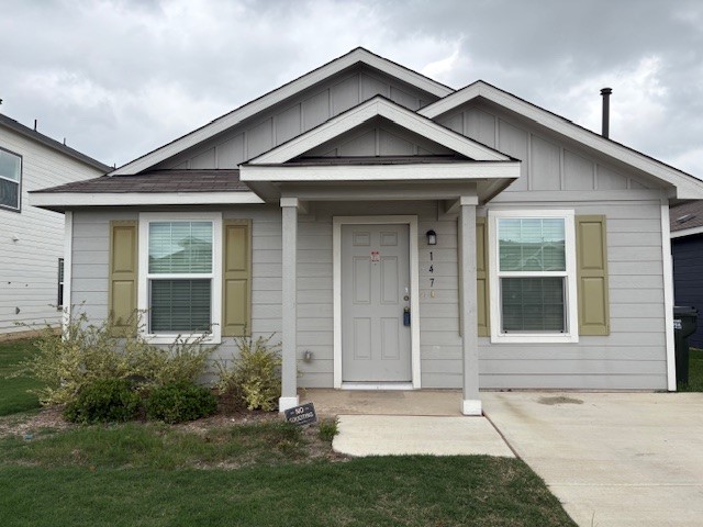 Single-story residence featuring light gray siding, a covered entry, and a dark shingled roof