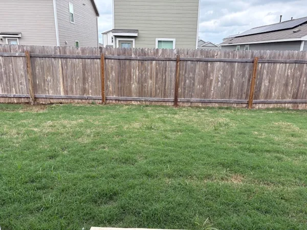 a view of a backyard with wooden fence