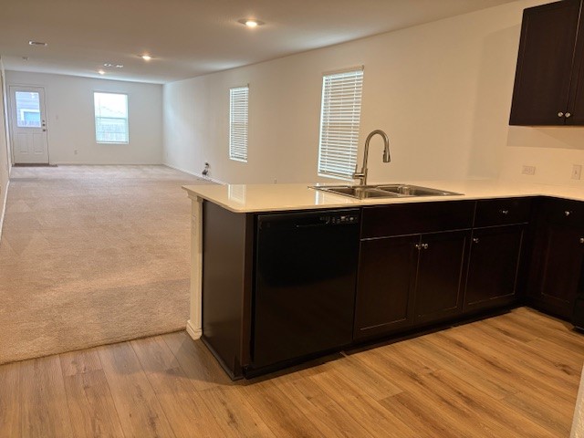 147 Gabbro Gardens Maxwell, TX 78656 - Photo 6 of 14 Kitchen island featuring an undermount double basin sink with a high-arc faucet, quartz countertop, and dark wood cabinetry