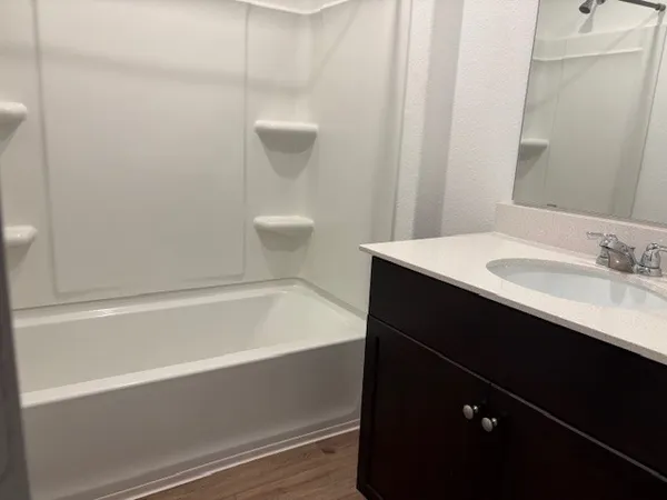 a bathroom with a sink a toilet a vanity and bathtub