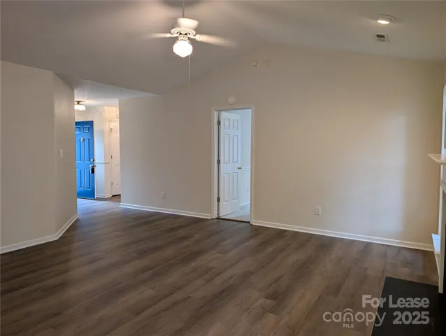 an empty room with wooden floor and ceiling fan