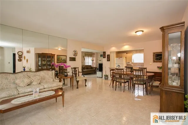 a living room with furniture and a dining table with kitchen view
