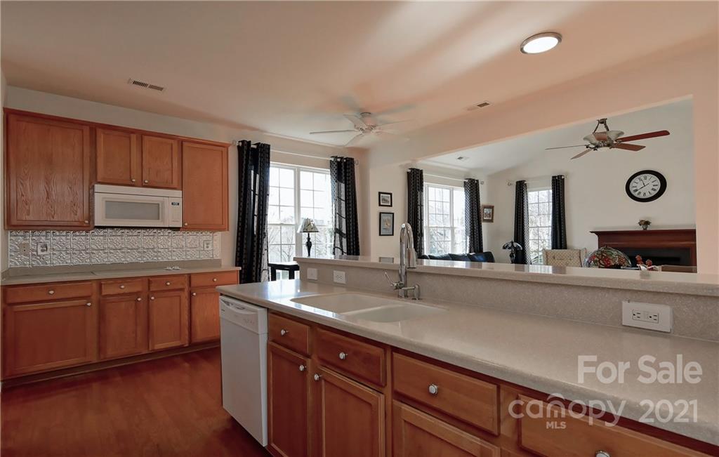 302 Garnet Court, Unit 522 Fort Mill, SC 29708 - Photo 13 of 45 a large kitchen with granite countertop a sink and dishwasher with a large mirror next to a window