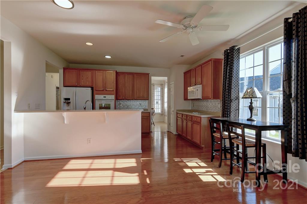 302 Garnet Court, Unit 522 Fort Mill, SC 29708 - Photo 14 of 45 a view of kitchen with stainless steel appliances granite countertop a stove top oven a sink a dining table and chairs with wooden floor