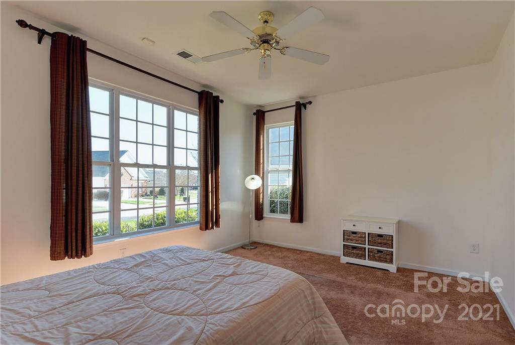 302 Garnet Court, Unit 522 Fort Mill, SC 29708 - Photo 27 of 45 a spacious bedroom with a balcony a bed and a chandelier