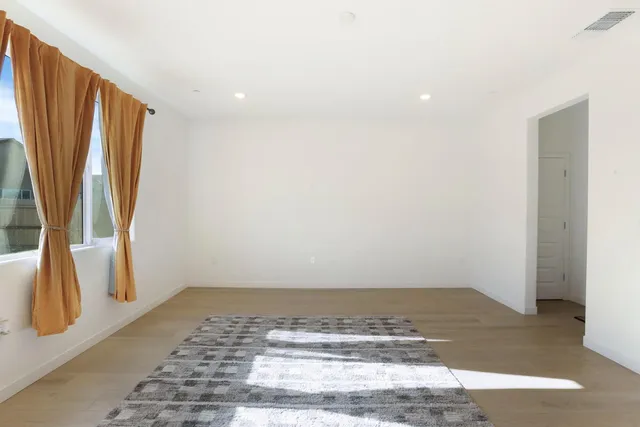 a view of a room with wooden floor and a window