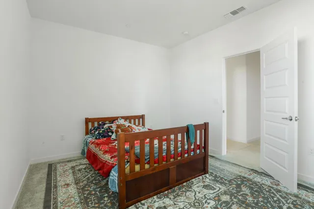 a bed sitting in a bedroom next to a window