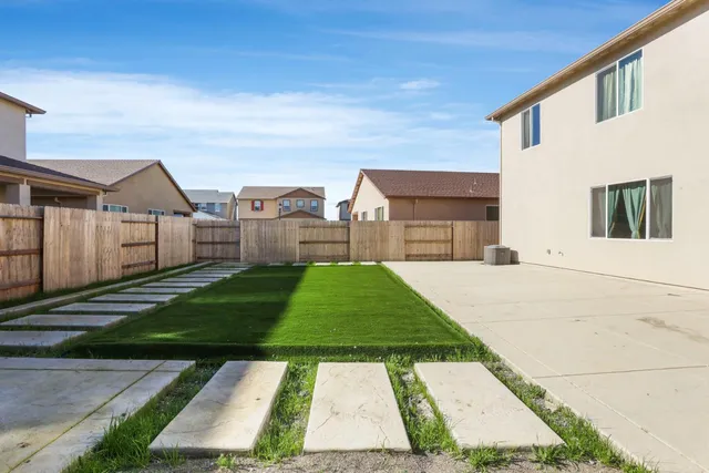 a view of backyard with table and chairs and wooden fence