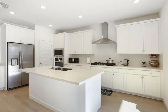 a kitchen with stainless steel appliances a stove refrigerator sink and cabinets