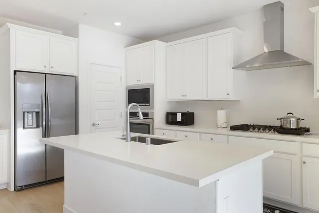 a kitchen with stainless steel appliances a sink a stove and a refrigerator