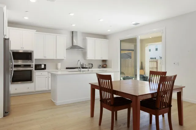 a kitchen with a dining table chairs and microwave