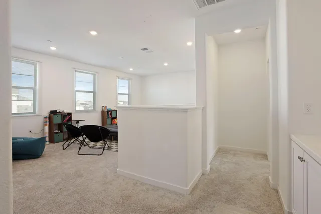 a living room with furniture and a refrigerator