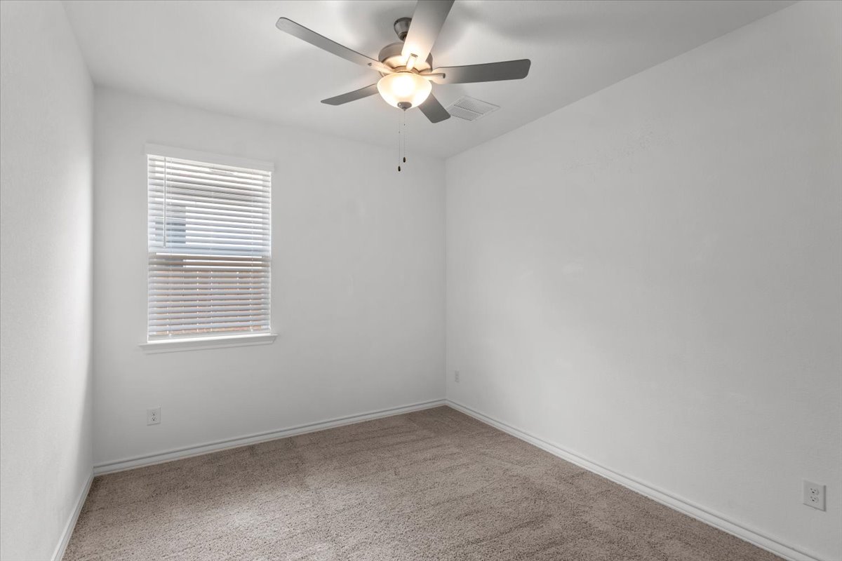 500 Stinchcomb Road Hutto, TX 78634 - Photo 22 of 37 Comfortable bedroom with carpeted flooring and a modern ceiling fan.