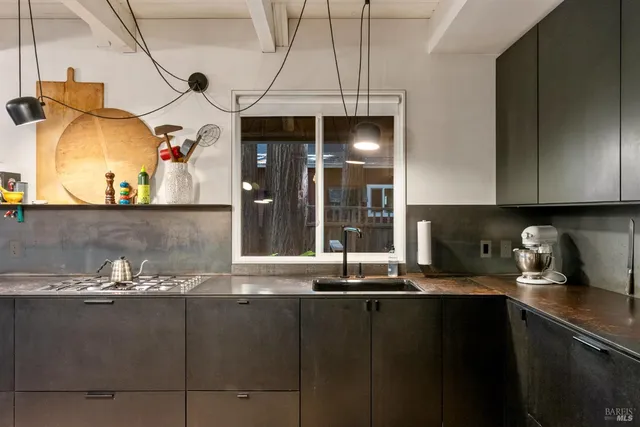 a kitchen with stainless steel appliances kitchen island granite countertop a sink a refrigerator and a stove