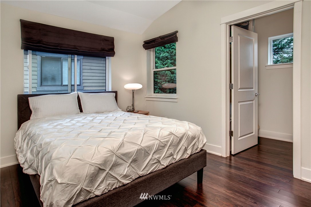 921 North 35th Street, Unit C Seattle, WA 98103 - Photo 13 of 17 a bedroom with a bed and wooden floor