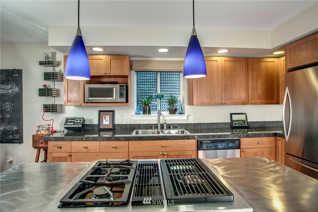 921 North 35th Street, Unit C Seattle, WA 98103 - Photo 5 of 17 a kitchen with stainless steel appliances a stove a sink a refrigerator a center island cabinets and a wooden floor