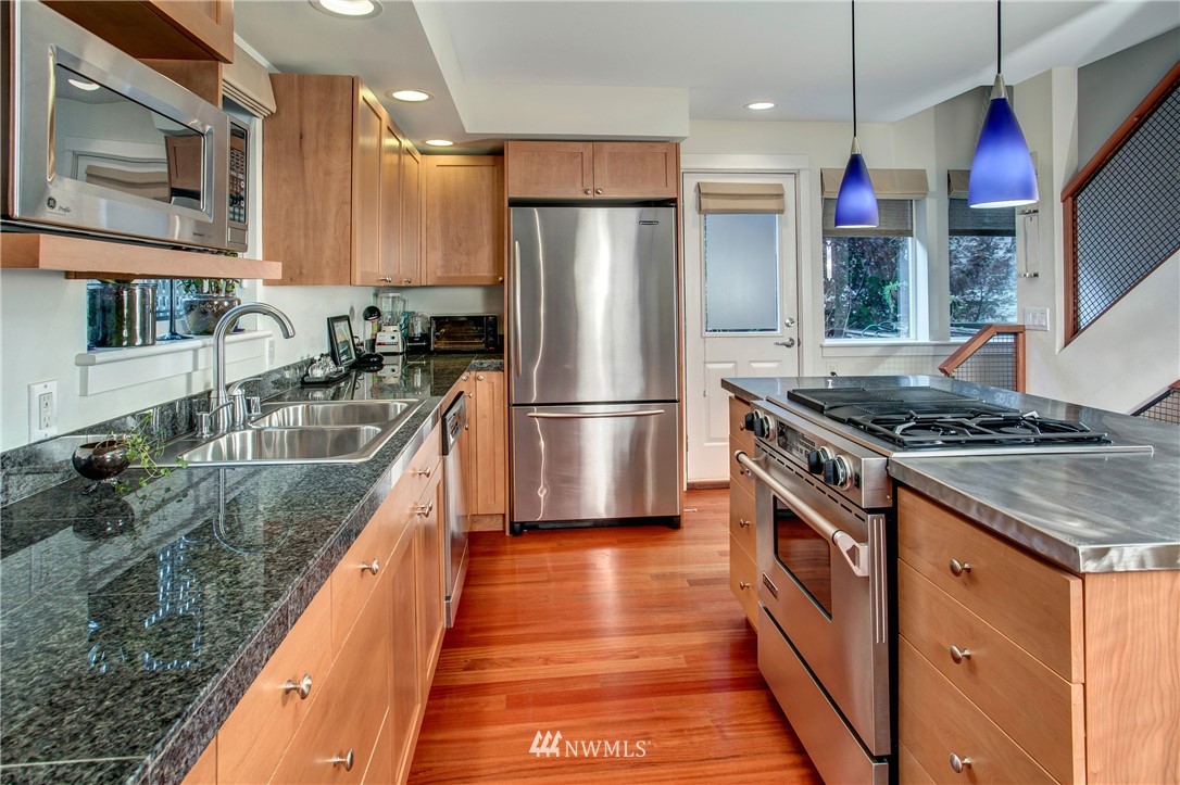 921 North 35th Street, Unit C Seattle, WA 98103 - Photo 6 of 17 a kitchen with stainless steel appliances granite countertop a stove a sink dishwasher a refrigerator and a oven