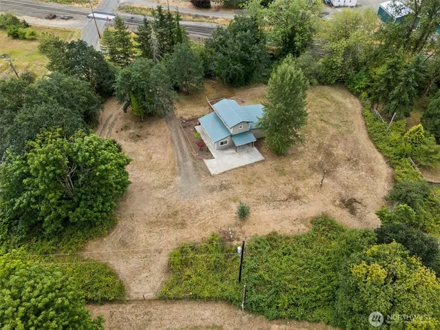 an aerial view of a house with a yard and tree s
