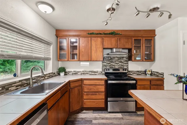 a kitchen with stainless steel appliances granite countertop a sink stove and refrigerator