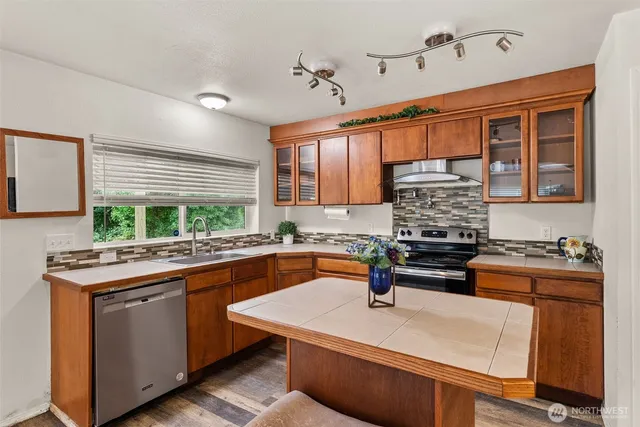 a kitchen with a stove a sink and a wooden cabinets