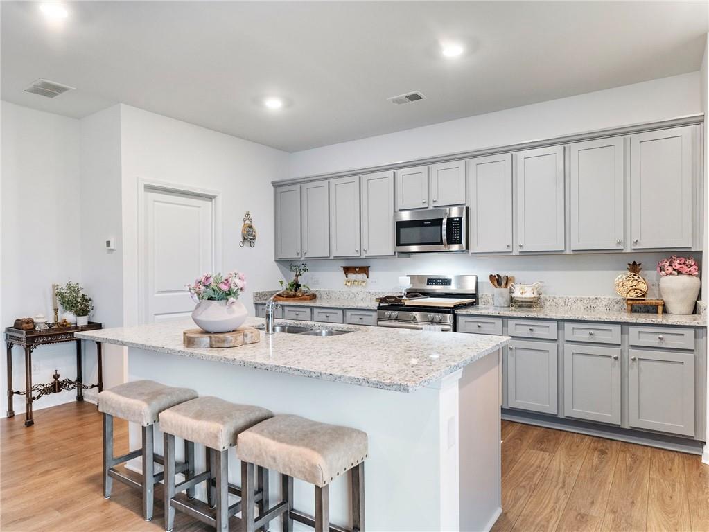 680 Groover Street Ball Ground, GA 30107 - Photo 11 of 42 a kitchen with granite countertop a sink and white cabinets