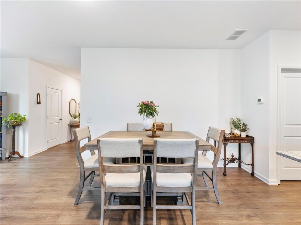 680 Groover Street Ball Ground, GA 30107 - Photo 9 of 42 a view of a dining room with furniture and wooden floor