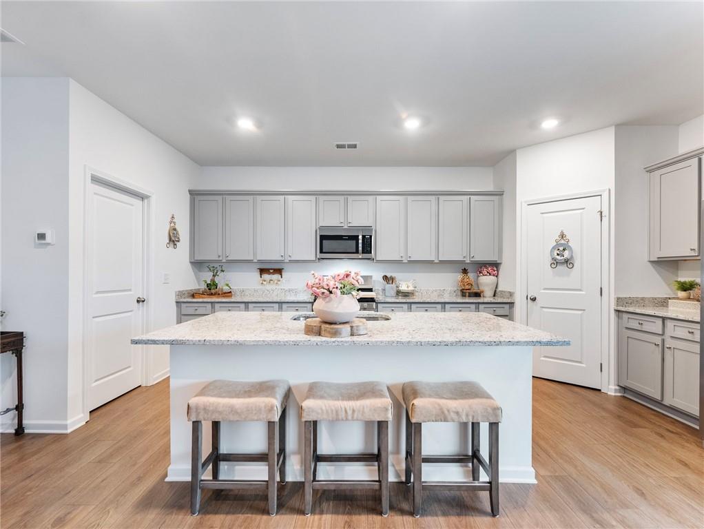 680 Groover Street Ball Ground, GA 30107 - Photo 10 of 42 a kitchen with stainless steel appliances granite countertop a table chairs sink refrigerator and cabinets