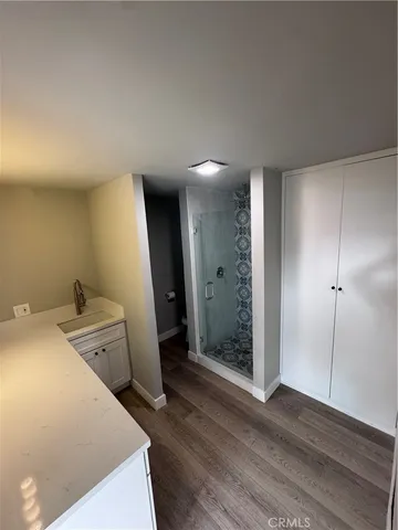 a view of a storage & utility room with closet wooden floor