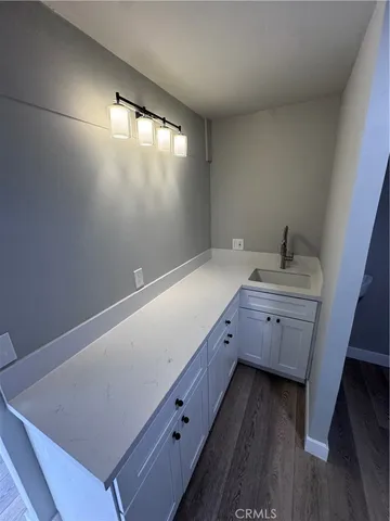 a room with a sink cabinets and wooden floor